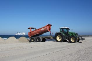 Tractor moving big amounts of sand at the beach